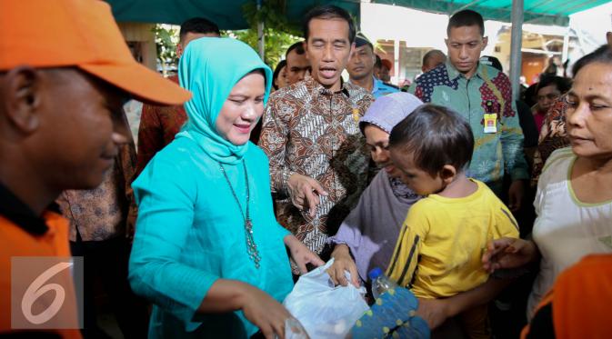 Presiden Joko Widodo didampingi Ibu Negara Iriana membagikan paket sembako saat blusukan ke Kedoya dan Petamburan, Jakarta, Selasa (1/9/2015). Selain sembako, Presiden Jokowi juga membagikan buku dan baju kepada anak-anak. (Liputan6.com/Faizal Fanani)