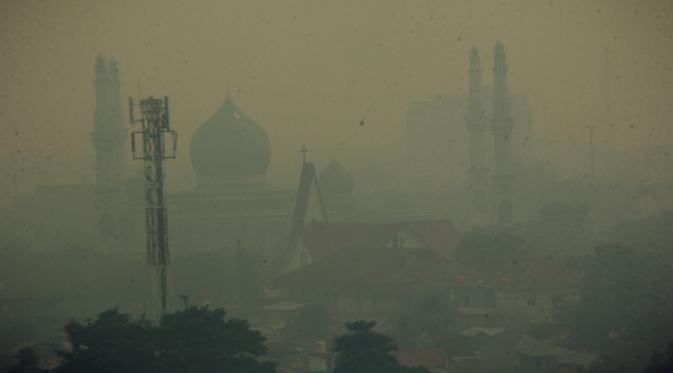 Kiriman asap kebakaran hutan dan lahan dari provinsi tetangga yang menyelimuti Kota Pekanbaru serta beberapa kabupaten di Riau, kian tebal. Jarak pandang di kota ini hanya 500 meter. (Liputan6.com/M Syukur)
