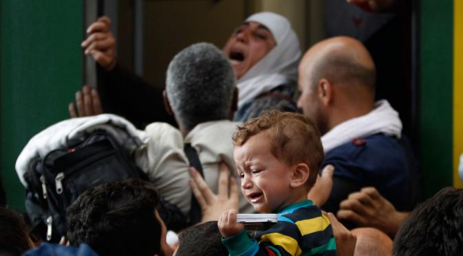 Seorang anak menangis di antrean penungsi yang hendak menaiki kereta.. | via: Petr David Josek/Associated Press