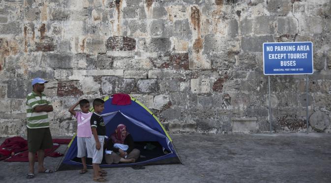 Perpaduan turis dan pengungsi di Kos, Yunani. | via: Yorgos Karahalis/Associated Press