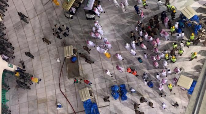 Sejumlah petugas berkumpul di dekat kerusakan yang disebabkan jatuhnya alat berat proyek (crane) di Masjidil Haram, Mekkah, Jumat (11/9/2015). Sebanyak 107 orang dilaporkan tewas, termasuk warga negara Indonesia. (AFP PHOTO / STR)