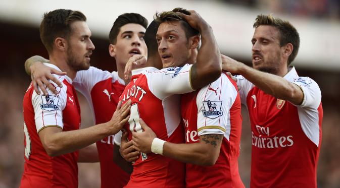  Theo Walcott celebrates with Mesut Ozil and team mates after scoring the first goal for Arsenal Reuters / Dylan Martinez