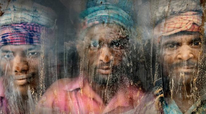 Para pekerja yang melihat keluar dari jendela yang penuh dengan debu, Chittagong, Bangladesh. | via: travel.nationalgeographic.com