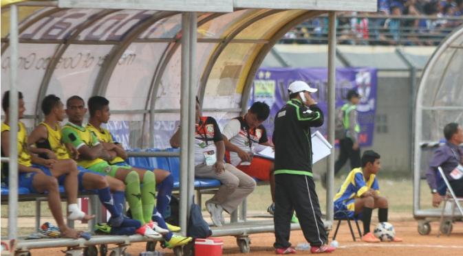 Asisten pelatih Persiba Balikpapan, Haryadi, sedang menerima instruksi dari Eduard Tjong melalui ponsel. Edu memantau dari hotel karena sakit diare (Bola.com/Robby Firly)