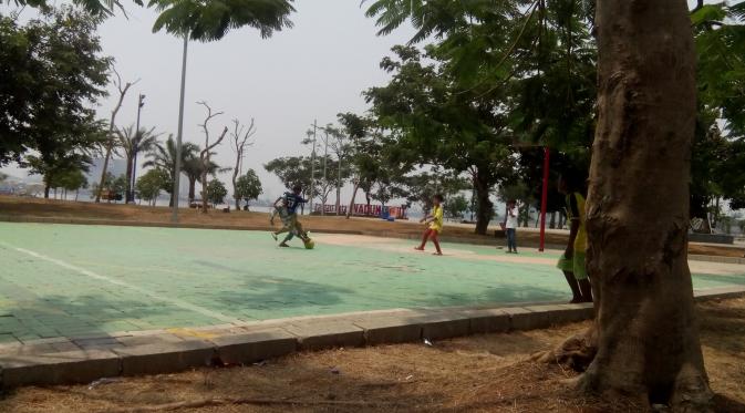 Lapangan basket yang sedang tidak bisa dipakai beralih fungsi sebagai tempat bermain bola. (Foto: Benedikta Desideria)