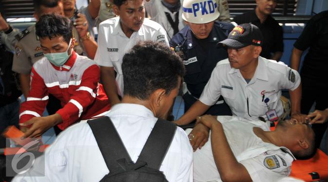 Masinis kereta rel listrik terlihat kesakitan saat akan dibawa kerumah sakit terdekat dengan Stasiun Juanda, Jakarta, Kamis (23/9/2015). Sekitar 34 penumpang KRL luka-luka akibat kecelakaan ini. (Liputan6.com/Gempur M Surya)
