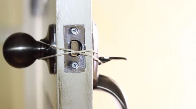 Ikat pakai karet engsel pintumu agar nggak mudah terkunci saat bolak-balik mengeluarkan barang. (Via: youtube.com)