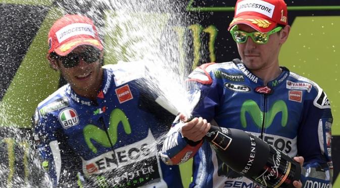 Valentino Rossi bersama Jorge Lorenzo (LLUIS GENE / AFP)